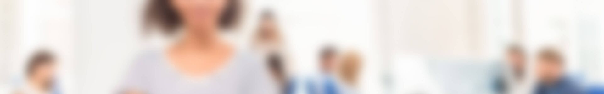 Mitarbeiterin steht in einem Großraumbüro